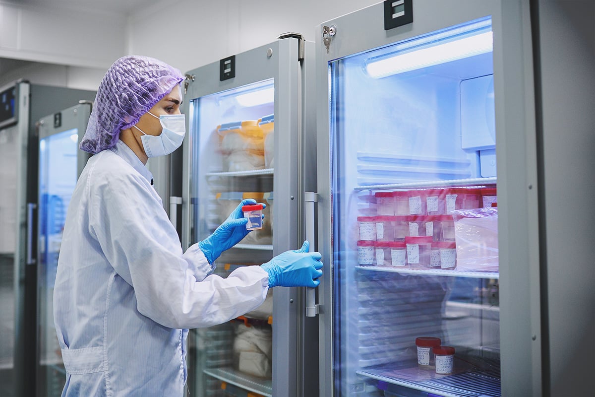 Scientist accessing laboratory refrigerator with stored samples